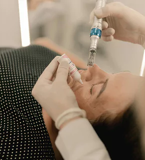 A woman undergoing a facial procedure with a machine, focused on skincare in a beauty salon.